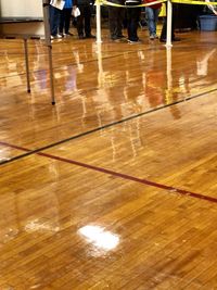 Low section of people on wooden floor in building