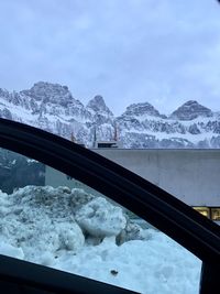 Snow covered mountains seen through car window