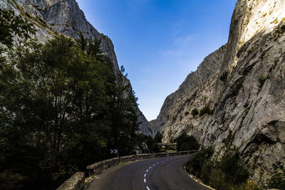 Road amidst rock formation against sky