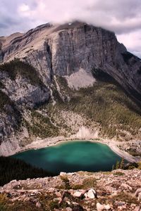 Scenic view of turquoise lake and mountains against sky