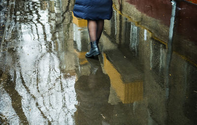 Female figure reflected in wet sidewalk