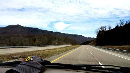 Vehicles on road with mountain in background