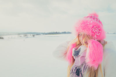 Woman with pink umbrella against sky during winter