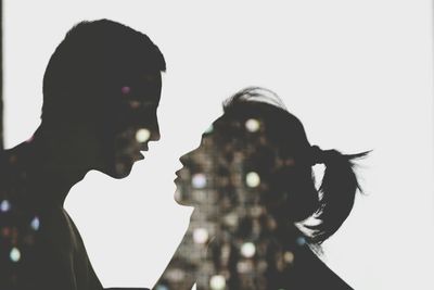 Close-up of silhouette couple against white background