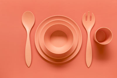 Directly above shot of eating utensils on orange background