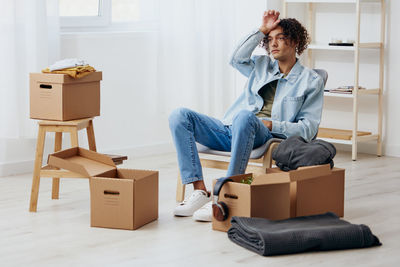 Portrait of young woman sitting on suitcase