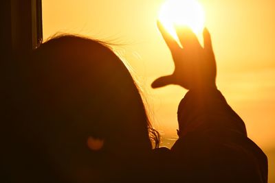 Portrait of silhouette woman against bright sun during sunset