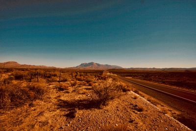 Scenic view of desert against clear blue sky