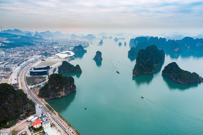 High angle view of cityscape by sea against sky