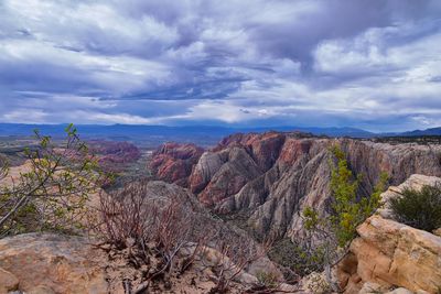 View of rocks on landscape against cloudy sky