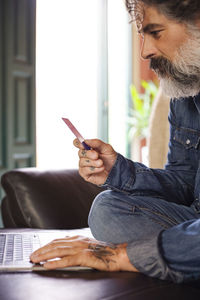 Man holding credit card and using laptop. businessman who works at home. online shopping, e-commerce