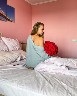 Woman sitting on bed at home