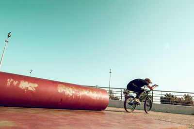 Man riding bicycle against clear sky