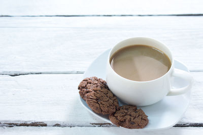 Close-up of coffee cup with cookies on table