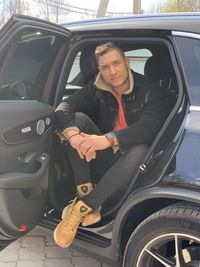 Portrait of young man sitting in car