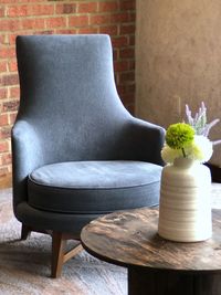 Flower vase on table against wall at home