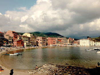 Buildings by sea against sky