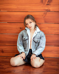 Young woman sitting on hardwood floor