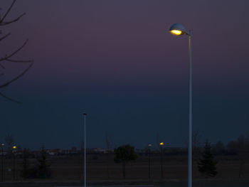 Low angle view of illuminated street light against sky