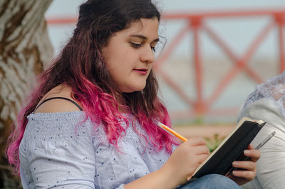 Close-up of young woman using mobile phone outdoors