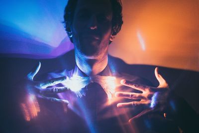 Close-up of man in illuminated room