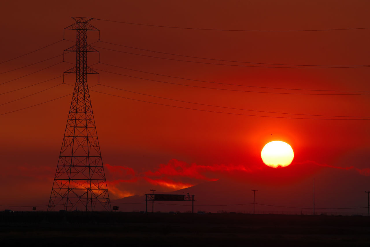 LOW ANGLE VIEW OF ELECTRICITY PYLON AGAINST ORANGE SKY