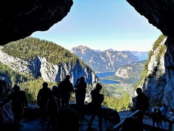 People looking at mountain range against sky