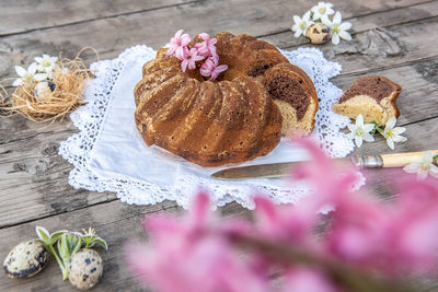 High angle view of cake on table with eggs and flowers