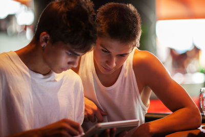 Friends using digital tablet while sitting in cafe