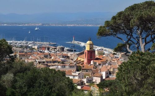 Cityscape by sea against sky