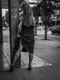 Rear view of woman walking on footpath