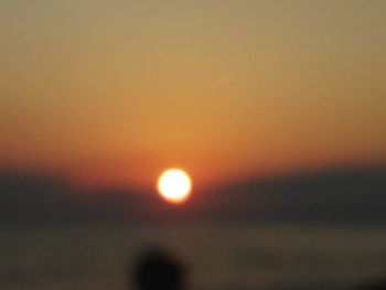 Defocused image of sea against orange sky