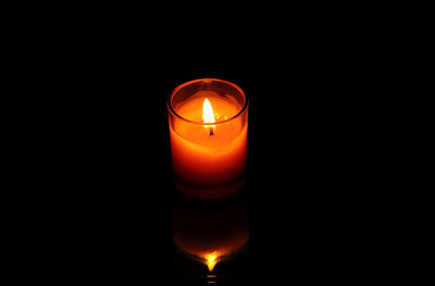 Close-up of lit candle in dark room