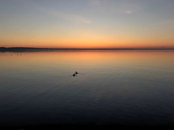 Scenic view of lake against sky at sunset