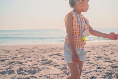 Full length of girl on beach against sky