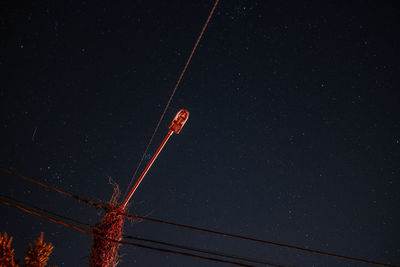 Low angle view of cables against sky at night