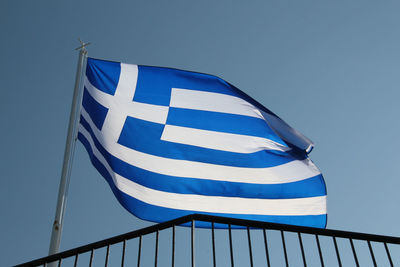 Low angle view of flag against clear blue sky