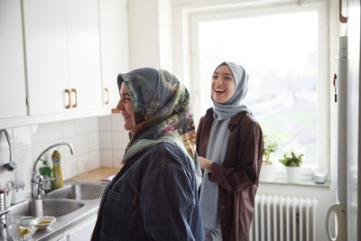 Women in headscarves cooking together for eid al-fitr at home