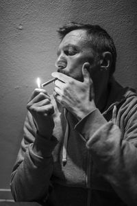 Close-up of man igniting cigarette at home