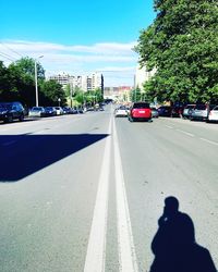 Shadow of person on road against sky