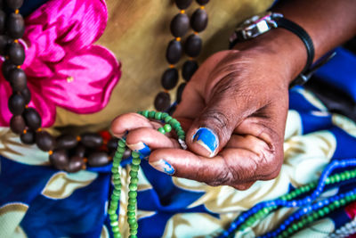 Midsection of woman making necklace