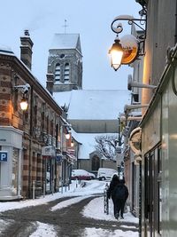 People walking on street amidst buildings during winter