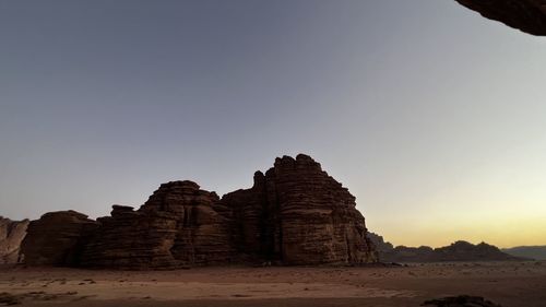 Ruins of rock formation against clear sky during sunset