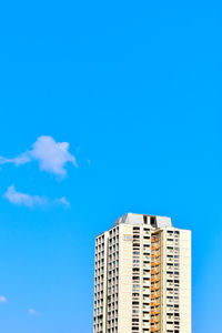 Low angle view of modern building against blue sky