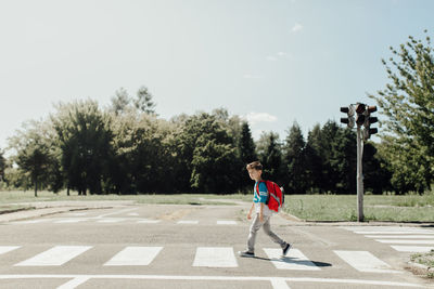 Boy playing on road against sky