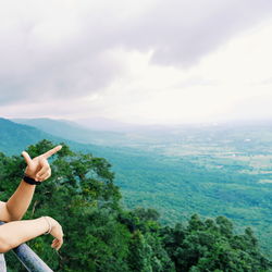 Man with umbrella on landscape against sky