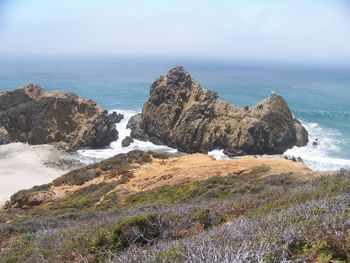 Scenic view of rocks on beach against sky