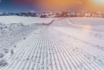 Tire tracks on snow covered landscape