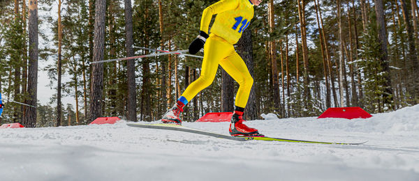 Male skier in yellow skin suit running ski race