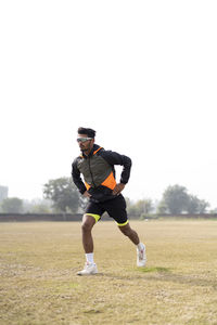 Young indian sportsman stretching in the field. sportsman warming up in the field.